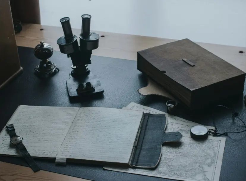 A desk with a journal, box and papers