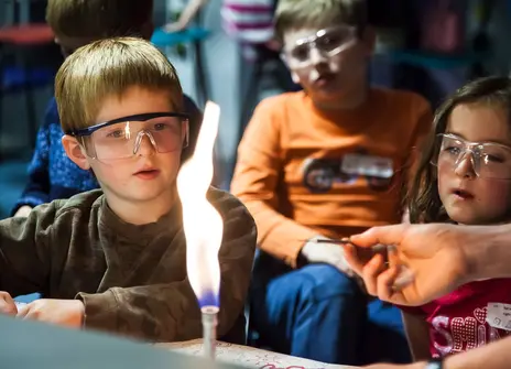 Children looking at a flame during a family fun day