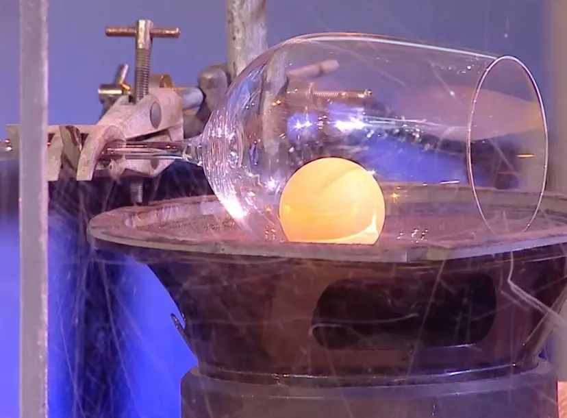 A wine glass tipped on its side with a ping pong ball inside it