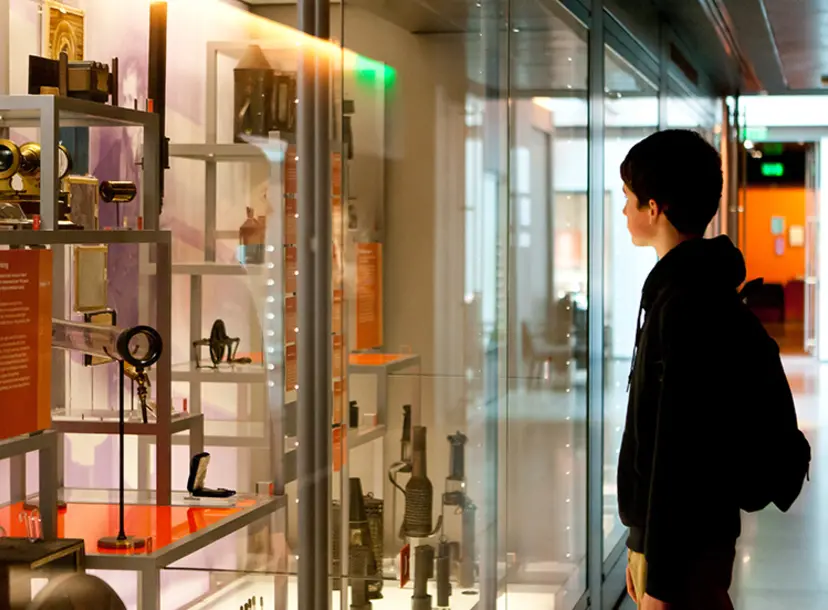 A child looking into the display cases of the Faraday museum
