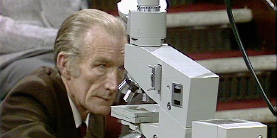 Bill Coates operating a large grey microscope
