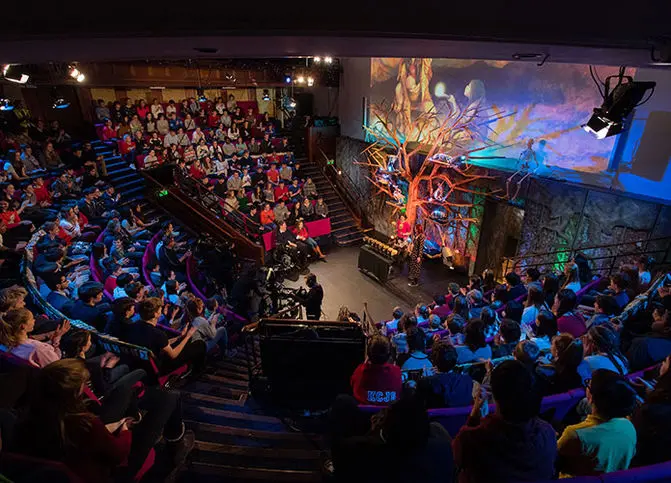 Ri lecture theatre with coloured LED lights and all the seats filled with kids watching the recording of the 2018 Christmas Lectures