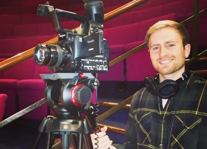 Jim holding onto a camera at the Ri lecture theatre
