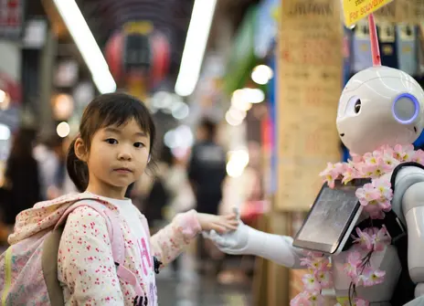 Little girl making friends with a robot