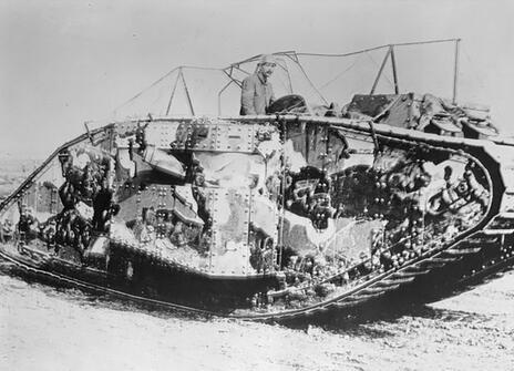 A black and white picture of a tank painted in camouflage pattern