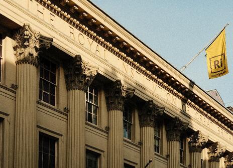 The outside of the Ri building with a yellow Ri flag being flown against a blue sky