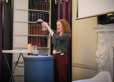 Maya doing a demonstration in the Ri Library, pouring coloured liquid 