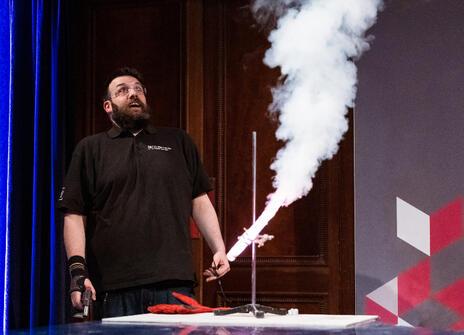 A man looks at a plume of smoke created by a demo