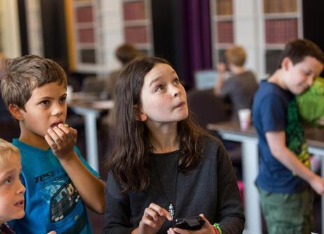 a child is looking up at a screen