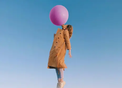 A women with a balloon floats in the air