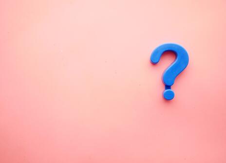 a blue question mark is on a pink background